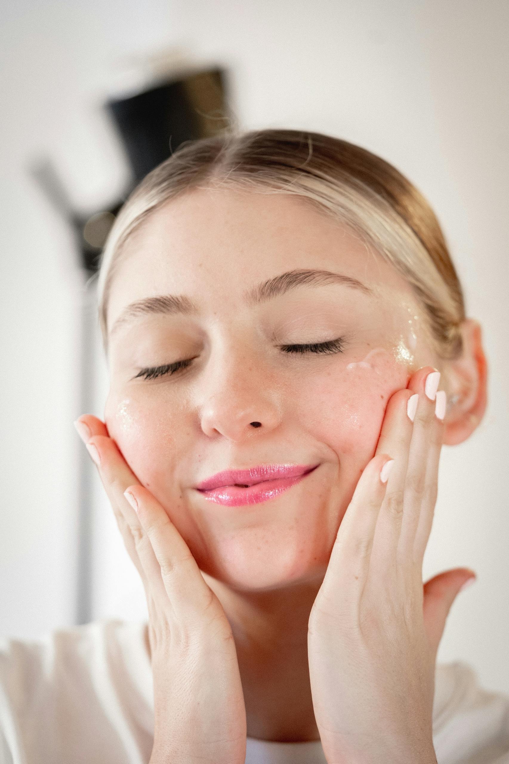 Close-up of a woman applying skincare cream, showcasing beauty and self-care.